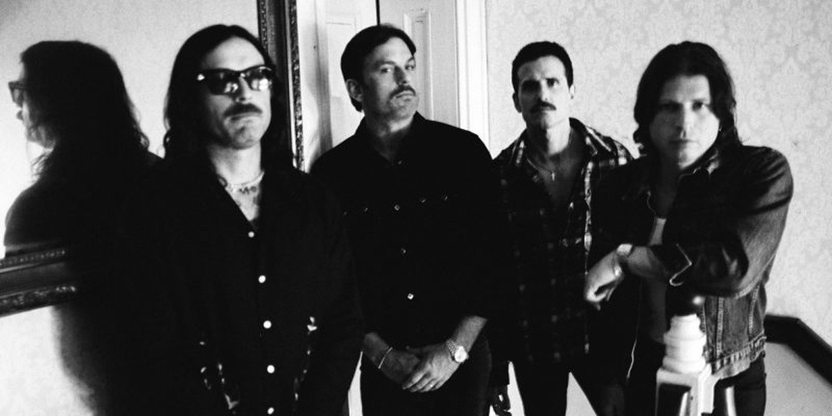 Kings of Leon pictured together in a black and white promotional photograph