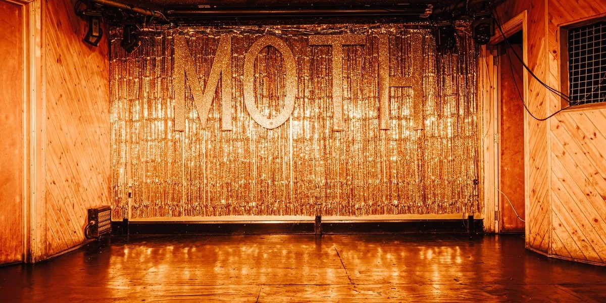 The gold curtain and MOTH lettering inside the empty main hall at MOTH Club.